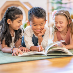 three children reading a book together